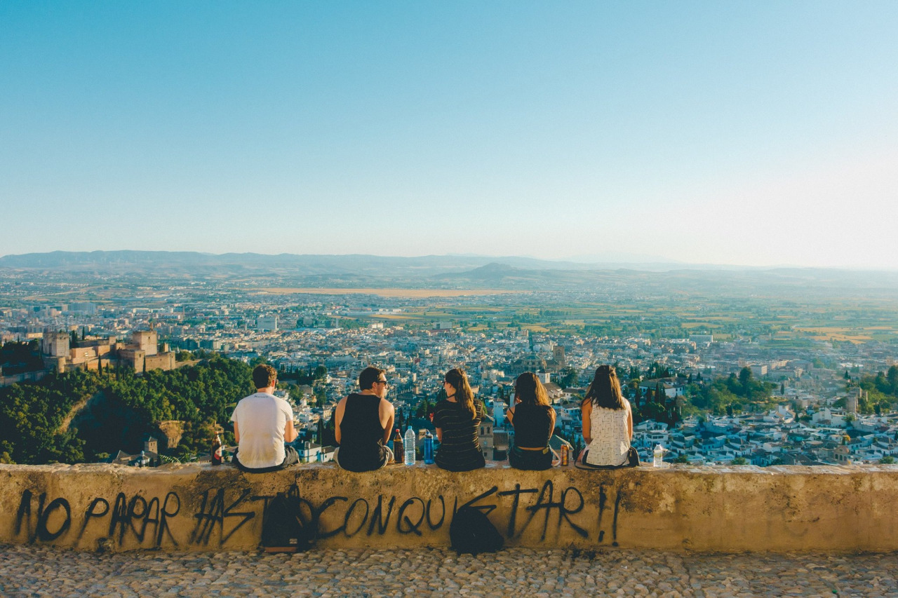 Teens sitting on a wall, overlooking Spain