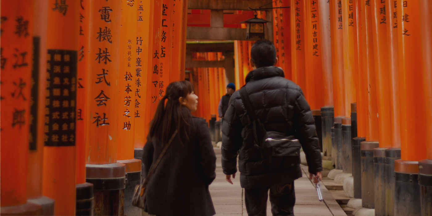 A person walking between many orange pillars