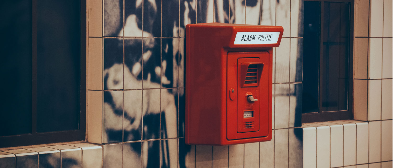 An emergency box to contact the police on a wall of graffiti