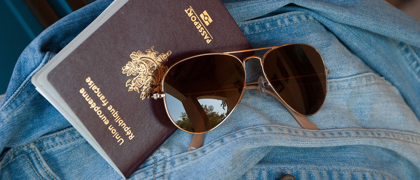 Passport with sunglasses on a jean jacket